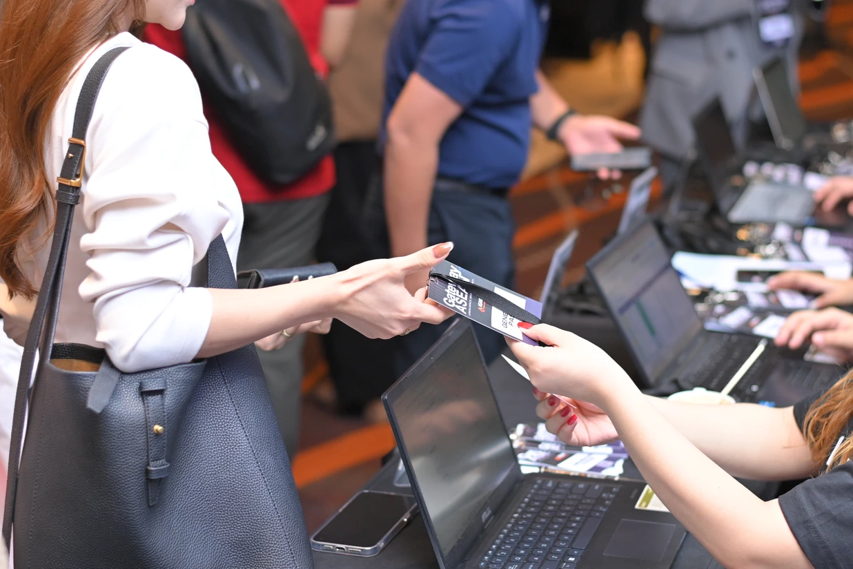 Guest receiving an event badge at the IGNITE registration desk