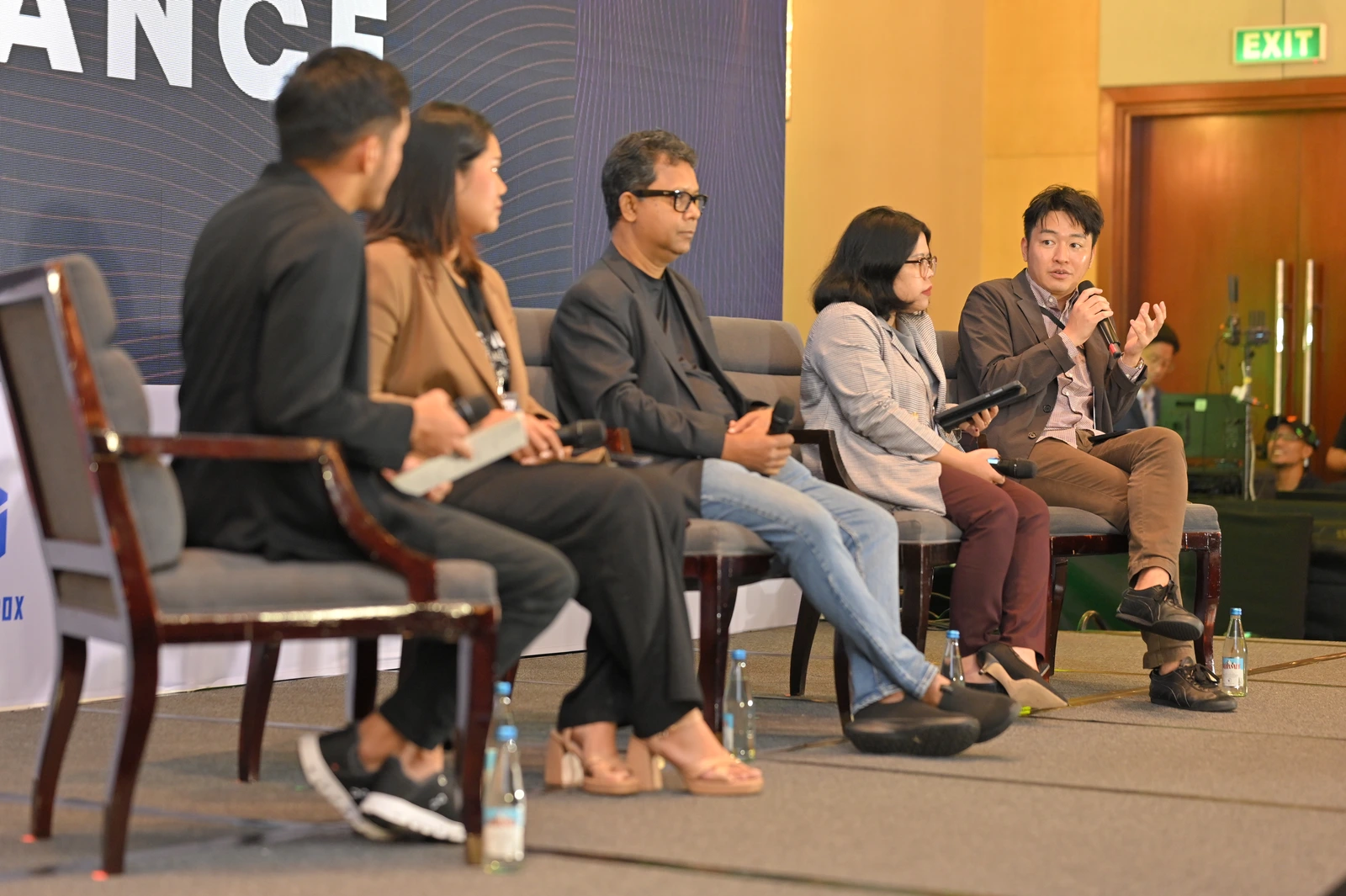 Five panellists seated on stage during a panel discussion at IGNITE